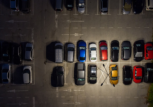 Aerial top view of parking lots with cars at night.