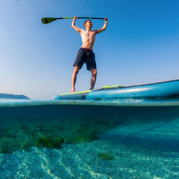 istock Young man on a paddleboard on the sea in summer 1413221995