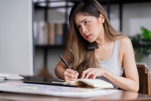 istock concentrate asian female busy working with client conversation checking data estimate via smartphone and tablet busy working in living room at home 1413222743