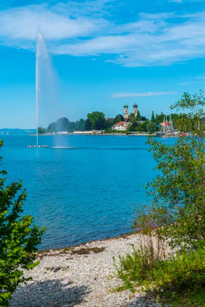 Photo of Germany, Friedrichshafen city marina at bodensee lake, houses and monastery in beautiful nature landscape in summer next to fountain in water