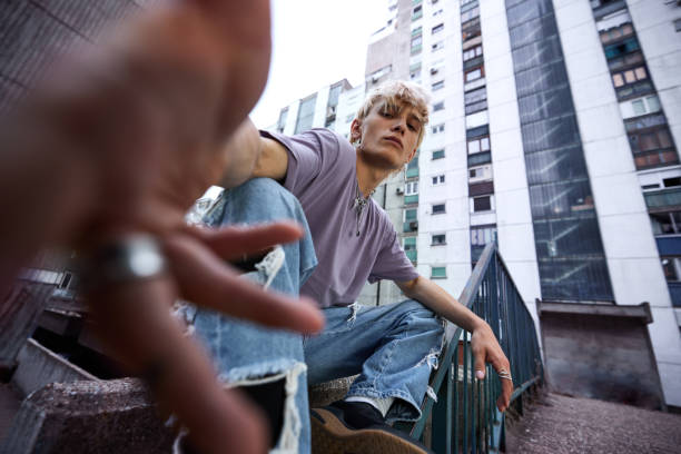 A teenage boy catching camera while posing in urban exterior.