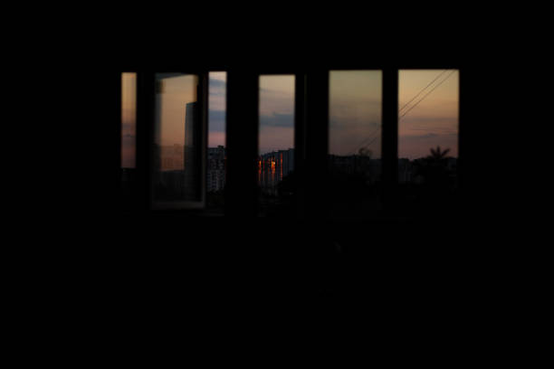 Beautiful evening sunset. Branches of trees and houses in the shade. View from the window