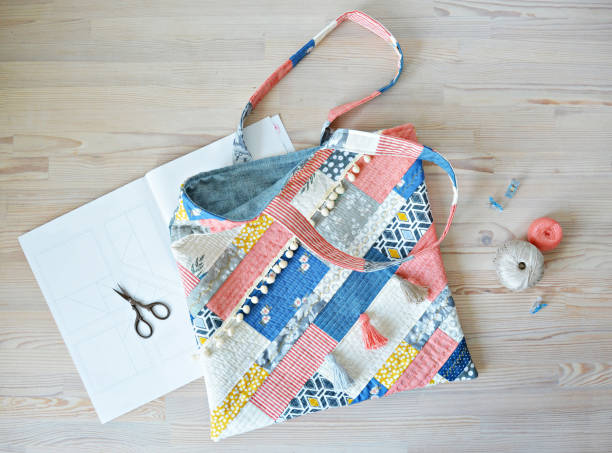 istock Quilted boho tote bag, scissors, clips and thread on wooden table 1413225818