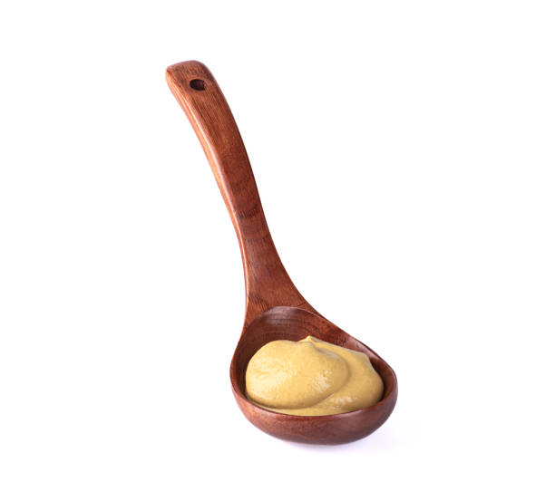 istock Wooden spoon with Dijon mustard isolated on white background. 1413227218
