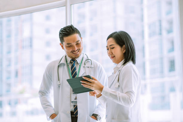 Male doctor and  female doctor discussing report stock photo