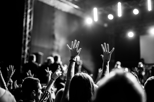 Young people dance during the pop music concert at the festival in Poland. Black and white.