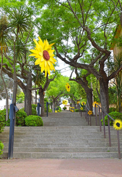 Curved outdoor staircase with colorful mosaic tiles and lush blooming bougainvillea climbing the railing and walls in Sunset Town, Phu Quoc island, Vietnam. Italian architecture in Asia. Romantic garden architecture