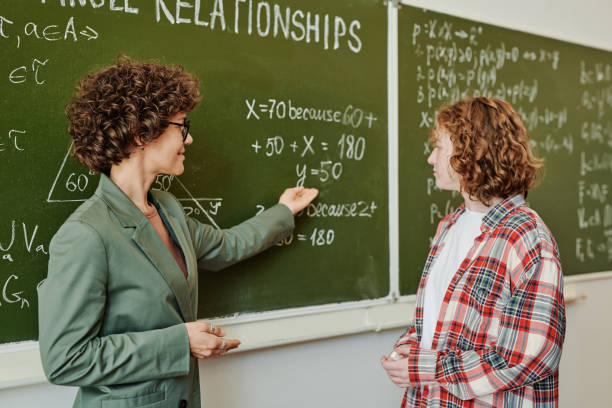 istock Confident teacher explaining female student how to solve equations 1413233190