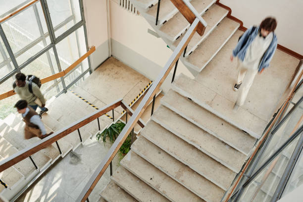 istock Students of modern university or other highschool moving along staircases 1413233403