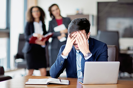 Portrait of burnout businessman under pressure in an office