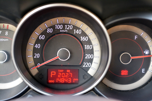 a car dashboard details set of a parking vehicle and engine is turned on, speedometer, RPM revolutions per minute, petrol meter and digital numbers of car kilometers, selective focus