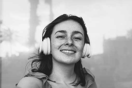 Portrait of natural looking middle aged woman against neutral background with copy space to right (black and white, selective focus)