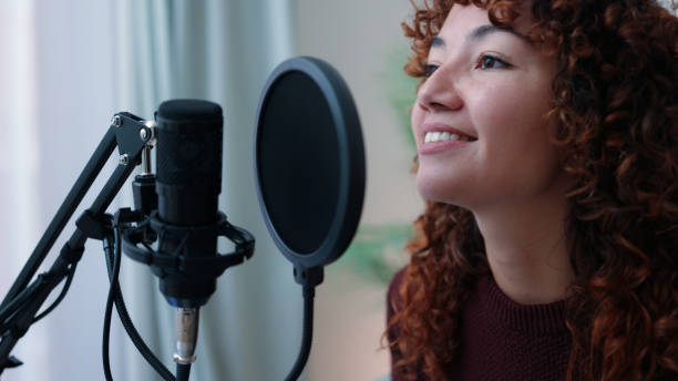 istock Young Latin host streaming live podcast on social media with microphone at home studio - Focus on face 1413236834