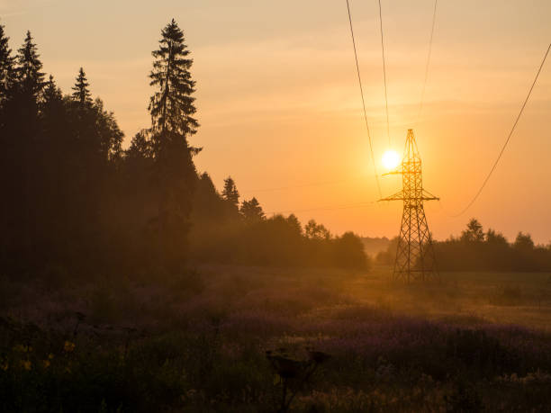 istock orange dawn with high voltage tower wires and nature 1413238102