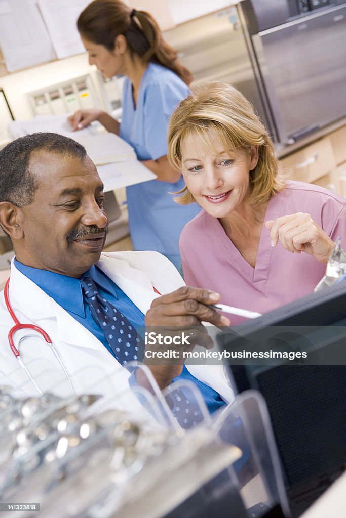 Arzt und Krankenschwester reden im Empfangsbereich - Lizenzfrei Schwesterntisch Stock-Foto