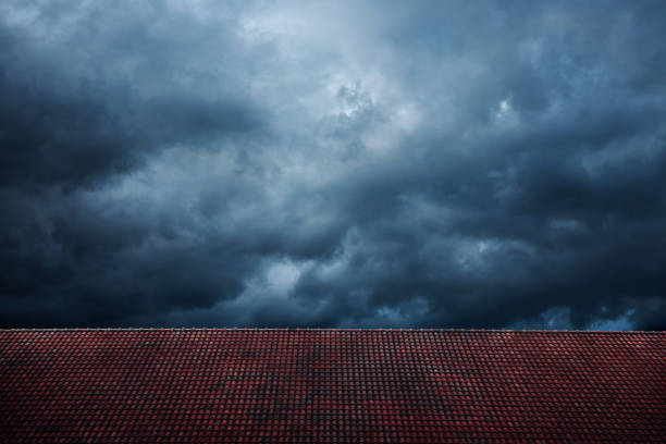 비와 폭풍 앞의 어두운 극적인 하늘. 사이클론은 블랙 윈디 클라우드와 함께 제공됩니다. 레드 타일 지붕에 의한 집 덮개를 전경으로. 날씨와 계절 변화 - lightning house storm rain 뉴스 사진 이미지