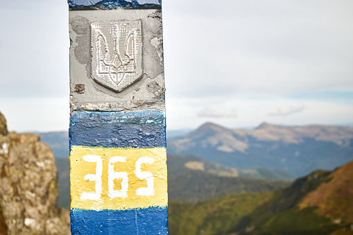 Ukraine STATE BORDER POST on Mountain range. Ukrainian border is marked with posts in national colors. Carpathian Mountain, Ukraine. Walking and hiking trails in Maramros ridge.