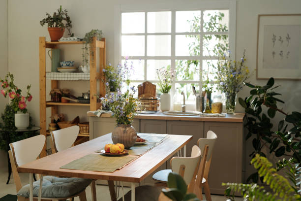 istock Cozy kitchen with wooden table in the center surrounded by sink with kitchenware 1413244595
