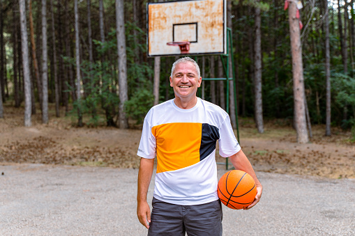 mature man posing on basketball court