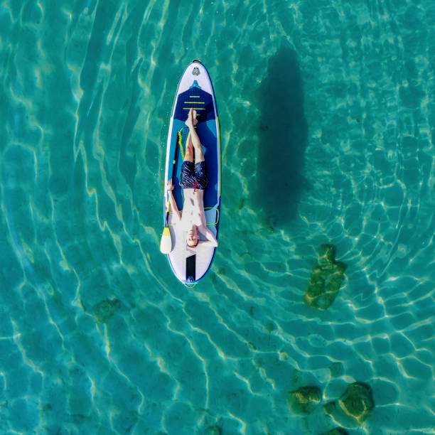 istock Young man on a paddleboard on the sea in summer 1413245442