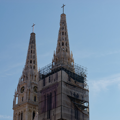 Close-up photo of a Zagreb Cathedral spires under reconstruction with a bright sky in the background, Zagreb, Croatia