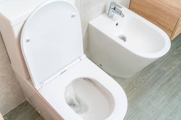 Toilet and bidet in a modern house. High angle view High angle view of an open white toilet and bidet in a modern apartment. toilet bowl stock pictures, royalty-free photos & images