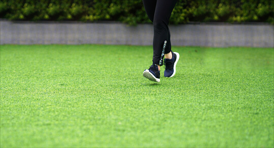 woman legs running in virtual lawn with running shoes
