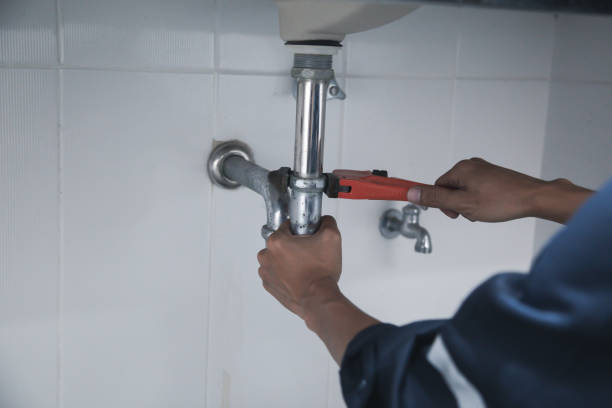 istock Male Plumber Using Wrench To Fix Leaking Sink In Home Bathroom. 1413259313
