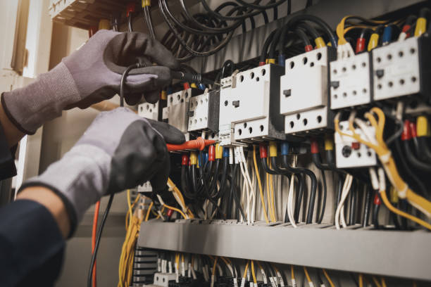 istock Electricity and electrical maintenance service, Engineer hand holding AC multimeter checking electric current voltage at circuit breaker terminal and cable wiring main power distribution board. 1413259874