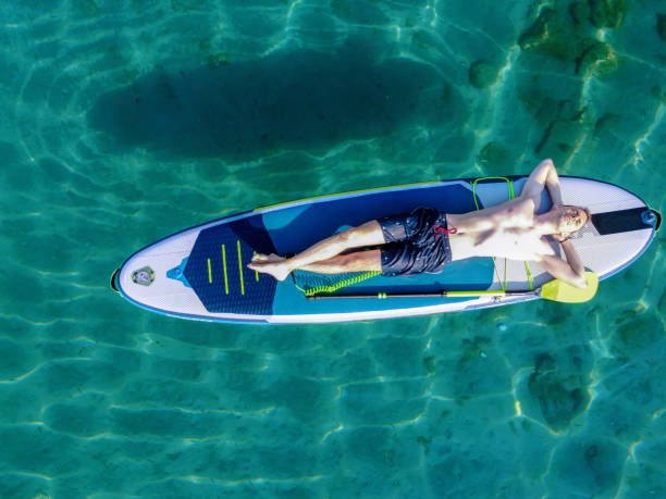 istock Young man on a paddleboard on the sea in summer 1413262705