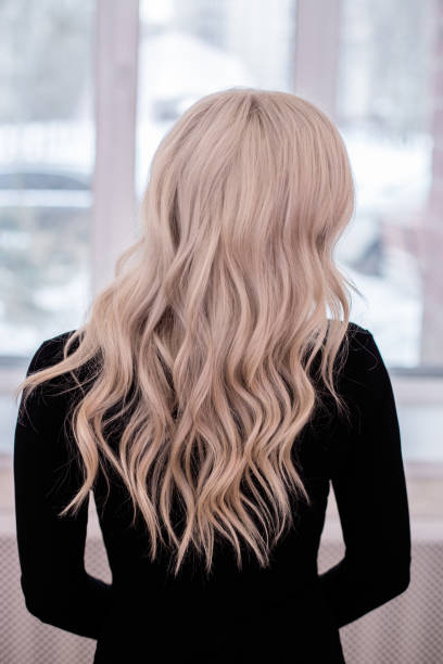 istock Female back with long, curly, blonde hair 1413265585