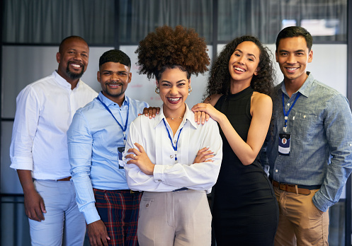 Portrait of group of young excited business people in formal wear standing in office