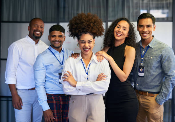 Happy, professional and corporate business people standing with arms crossed in an office together at work. Portrait of a manager leading a team and smiling with arms folded while standing in line Happy, professional and corporate business people standing with arms crossed in an office together at work. Portrait of a manager leading a team and smiling with arms folded while standing in line cheering group of people success looking at camera stock pictures, royalty-free photos & images