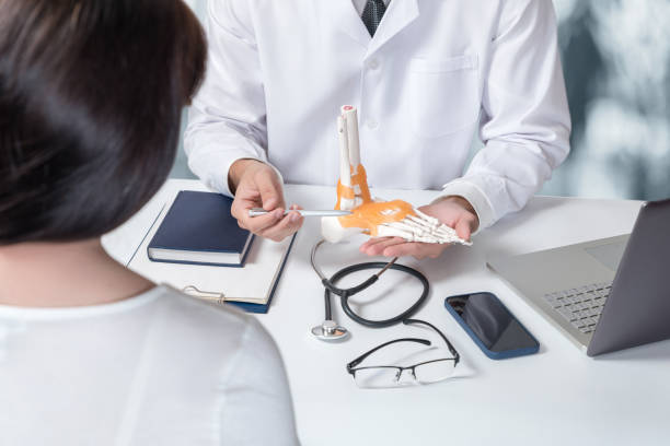 istock Doctor showing the patient the ankle joint . 1413269431
