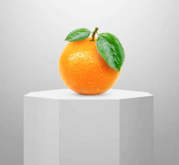 orange fruit, on shiny white round pedestal podium - gift orange green package imagens e fotografias de stock