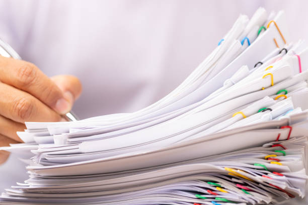 istock Man in a white shirt sign contract agreement documents in Stack of Group report papers. 1413272310