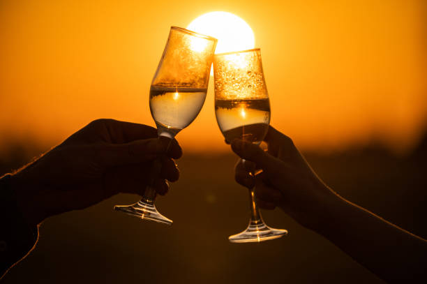glasses of champagne against the sun stock photo