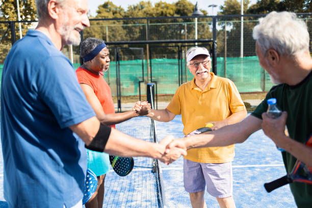 istock Four senior friends shaking hands before playing padel match 1413274541