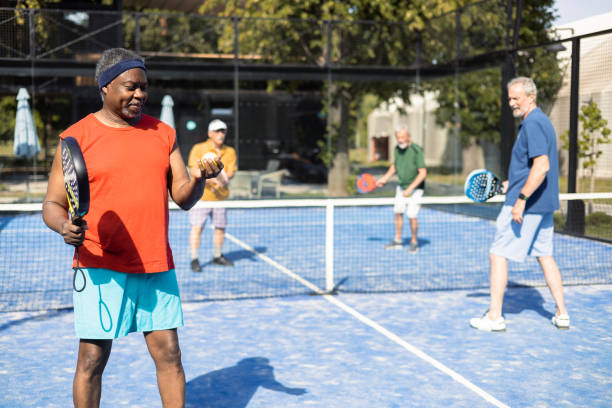 Senior African American playing padel with his friends stock photo