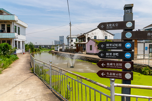 Wenzhou, China - June 23, 2022: Information signs in a canal where the water is flowing. A walkway is by the side. No people in the scene.