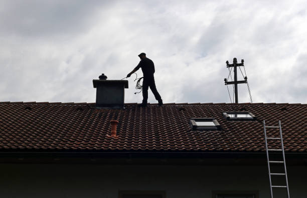 A chimney sweep cleans the chimney on a house roof A chimney sweep cleans the chimney on a house roof chimney stock pictures, royalty-free photos & images