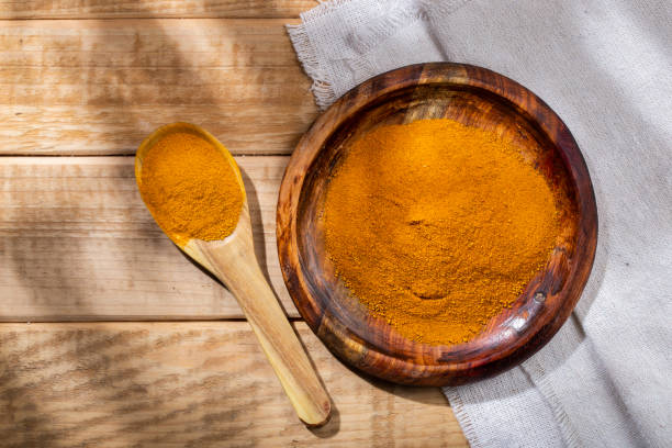 istock Turmeric powder in bowl on the table, top view 1413284648
