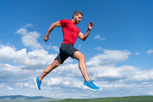 sportsman man runner run to success or jump high on sky background, sport.