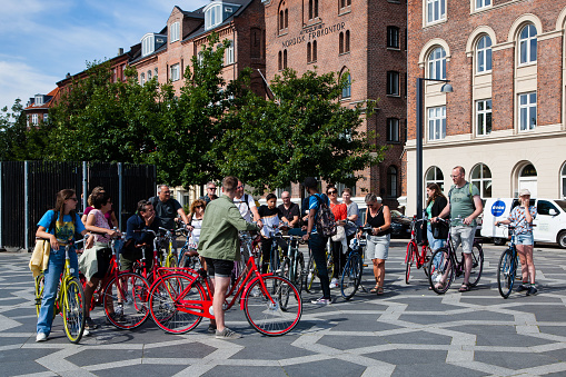 July 29, 2022: Large standing group of people on colorfull bikes seen on a beautiful summer day in Copenhagen, Denmark