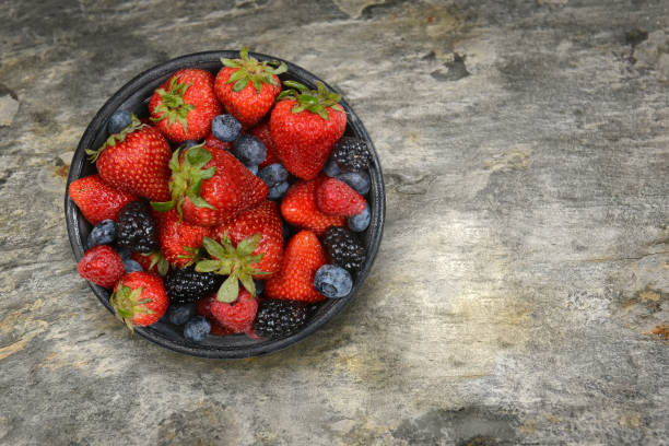 istock A bowl filled with fresh ripe berries on a slate table top, with copy space. 1413287505