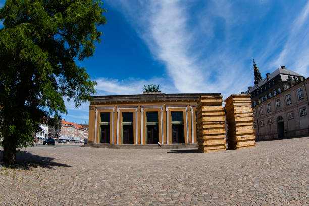 July 29, 2022: Thorvaldsens Museum in central Copenhagen. The two wooden towers in front of the museum is part of an exhibition. Shot with a fisheye lens on a beautiful summer day in Copenhagen, Denmark