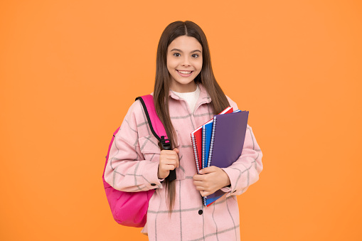 Back to class. cheerful student hold notebooks and books. back to school. teen girl in checkered shirt. happy kid casual style carry backpack. tween child with school bag. childhood and education.