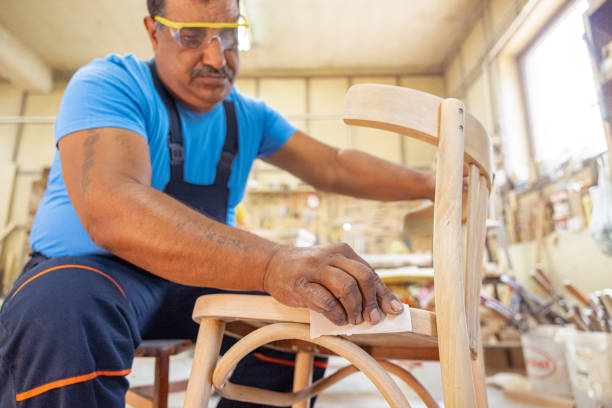 istock Indian carpenter working alone in his workshop. He is wearing safety glasses 1413288979