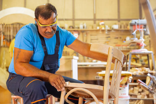 istock Indian carpenter working alone in his workshop. He is wearing safety glasses 1413289578