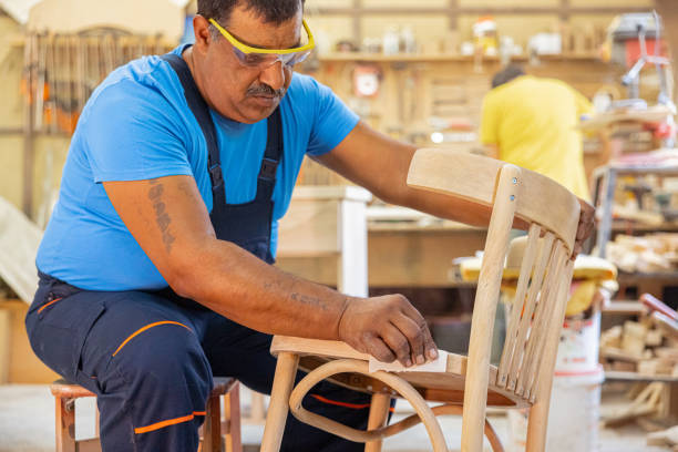 istock Indian carpenter working alone in his workshop. He is wearing safety glasses 1413289581
